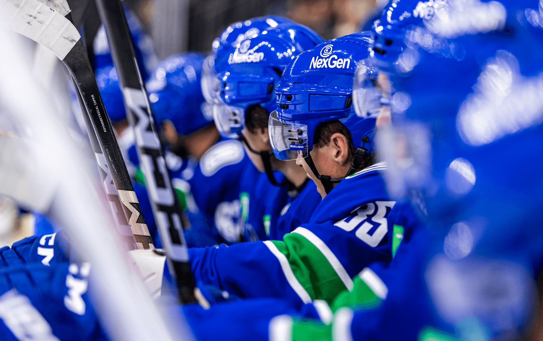 Ty Halaburda and other players look on from the bench in the Vancouver Canucks vs. Edmonton Oilers game at the 2024 Young Stars Classic from Penticton, BC.