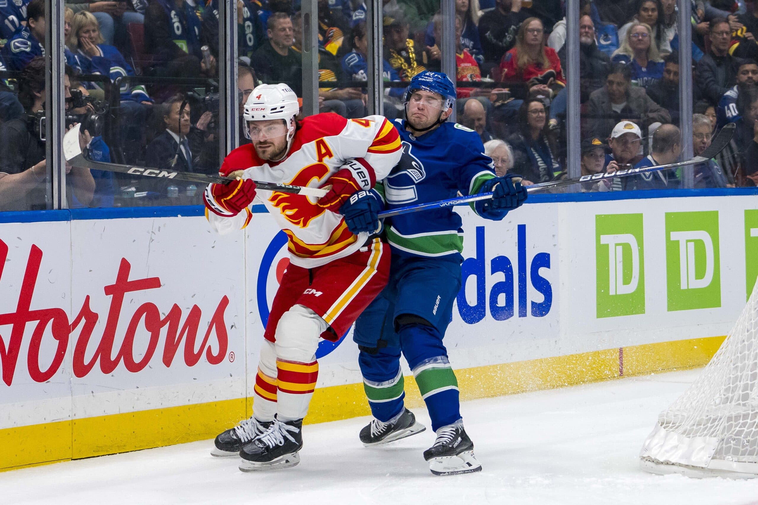 Vancouver Canucks forward Nils Hoglander (21) battles with Calgary Flames defenseman Rasmus Andersson (4) during the second period at Rogers Arena.