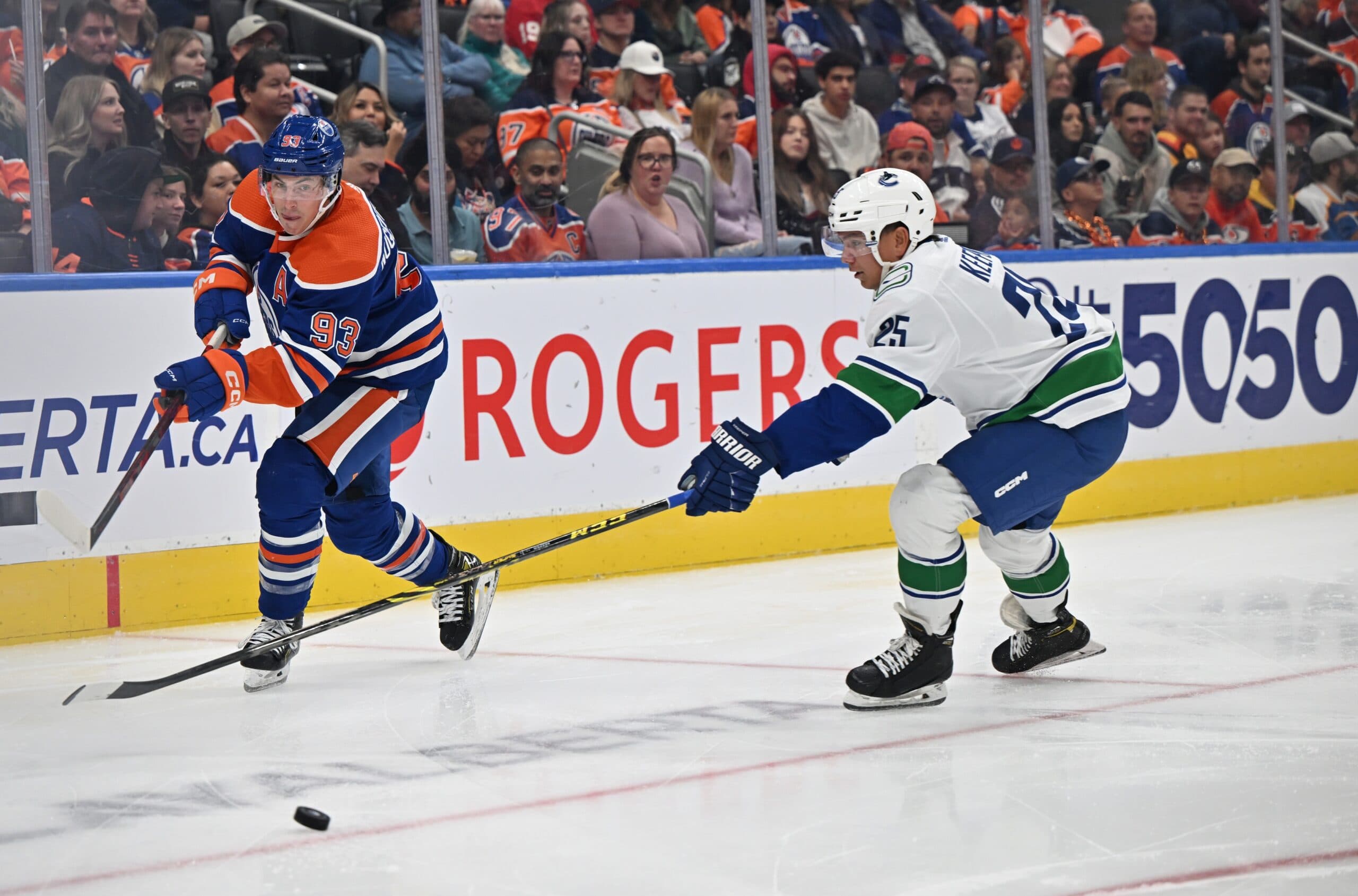 Oilers center Ryan Nugent-Hopkins (93) and Vancouver Canucks defenseman Brady Keeper (25) chase the puck during the third period at Rogers Place. Oilers won the game 7-2.